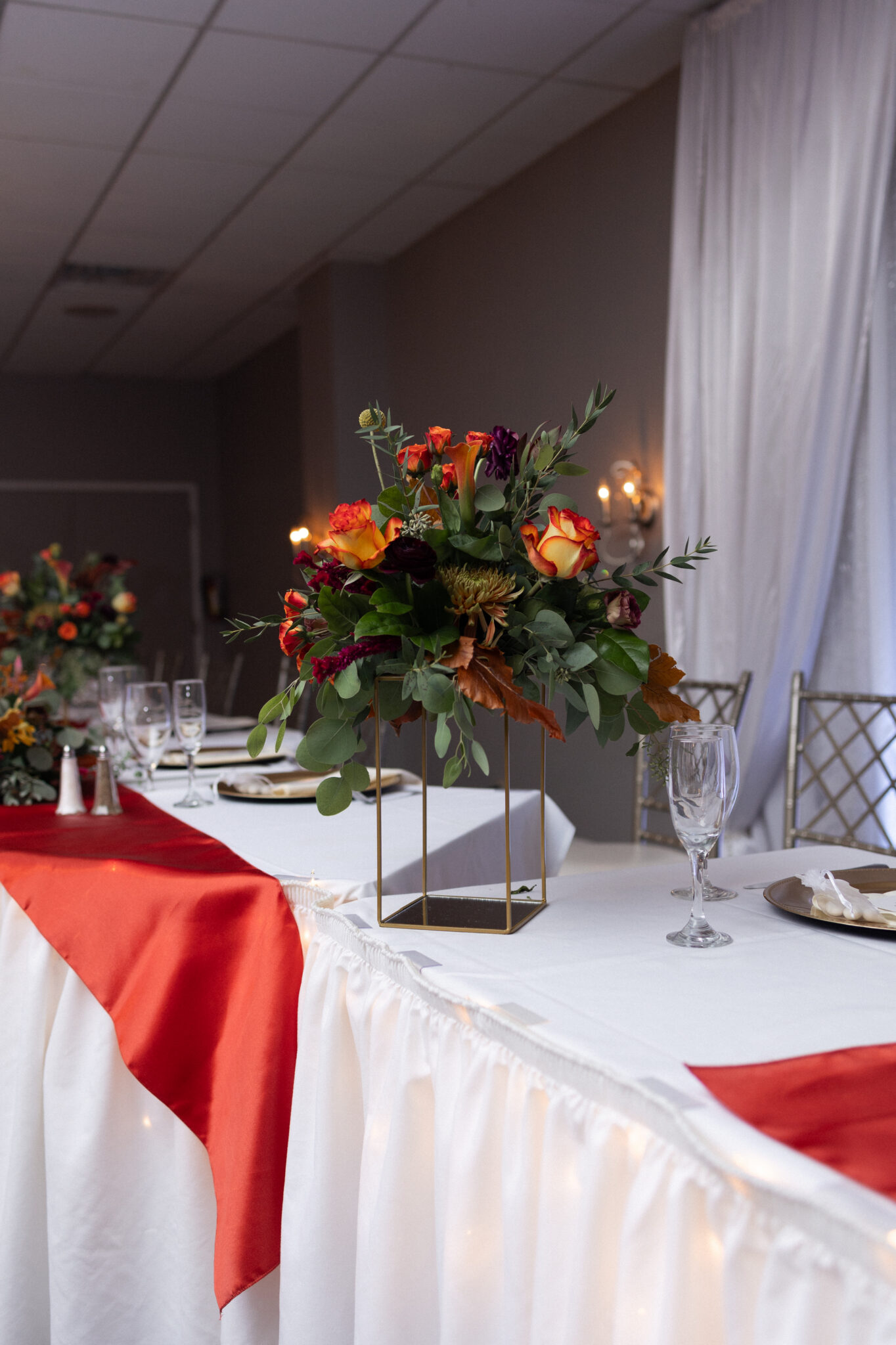 Tall floral centerpiece over a candlelit table