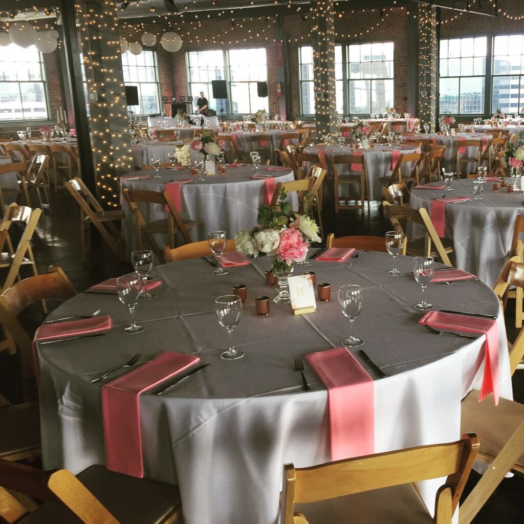 Reception room glowing with string lights and pink napkins
