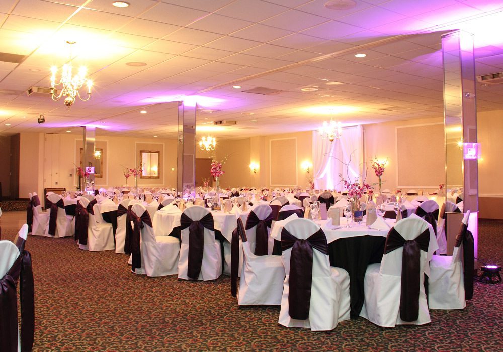 O’Fallon ballroom set for a wedding with round tables, chandeliers and uplighting
